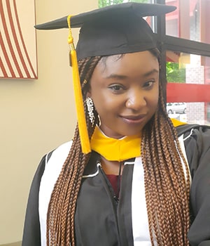 Janet Mosugu, the first recipient of the Margaret Foti Scholarship, wearing her graduation gown from Temple University Klein College of Media and Communication.